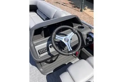 Slide: The Image of 2026 Sun Tracker SportFish 22 DLX boat dashboard with steering wheel and controls. - 2