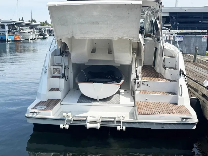 Slide: The Image of 2015 Beneteau Gran Turismo 44 yacht docked, showcasing open stern with tender storage. - 25