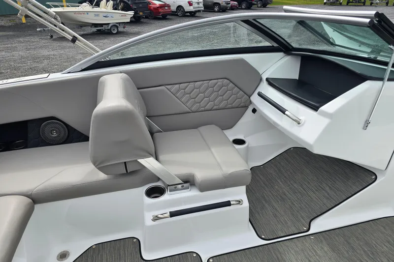 Slide: The Image of 2023 Four Winns H1 boat interior with gray cushioned seating and hexagonal pattern design. - 13