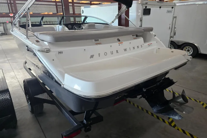 Slide: The Image of 2023 Four Winns H1 boat on trailer, close-up view of hull and registration. - 4