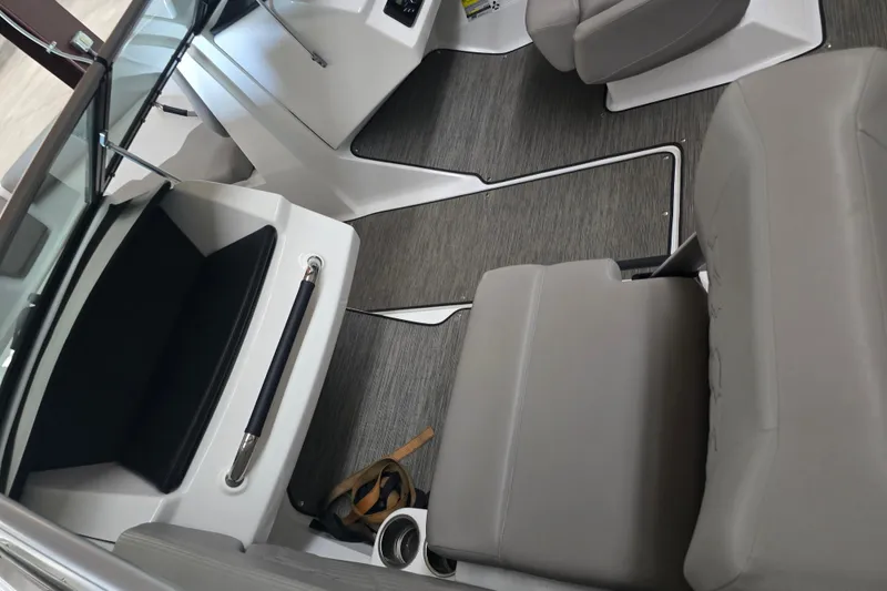 Slide: The Image of 2023 Four Winns H1 boat rear view with propeller, parked near green building. - 6