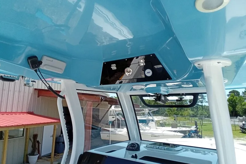Slide: The Image of 2022 Sportsman Open 302 Center Console boat interior with blue ceiling and control panel. - 12