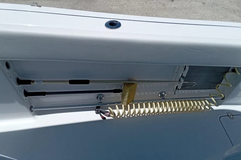 Slide: The Image of 2022 Sportsman Open 302 Center Console boat interior with rod holders and coiled hose. - 18