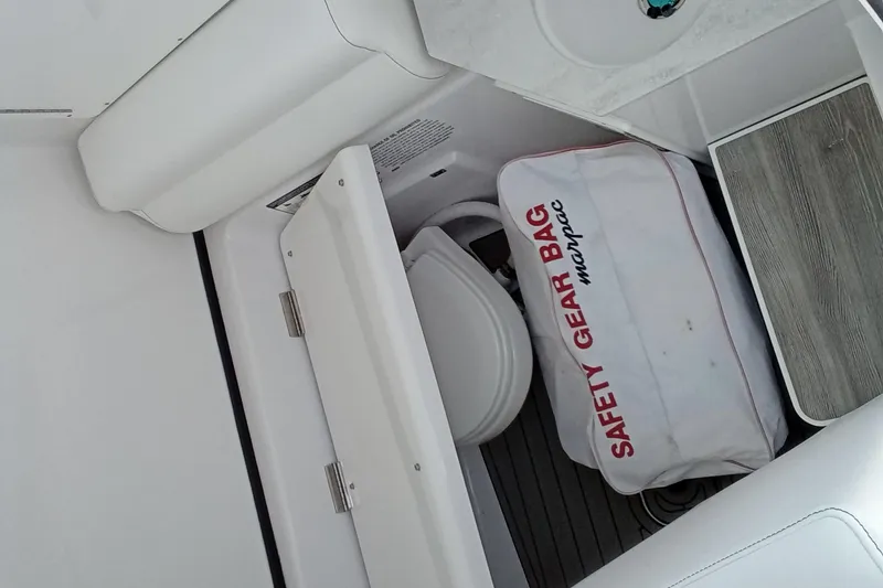 Slide: The Image of 2022 Sportsman Open 302 Center Console interior with safety gear bag and toilet. - 29