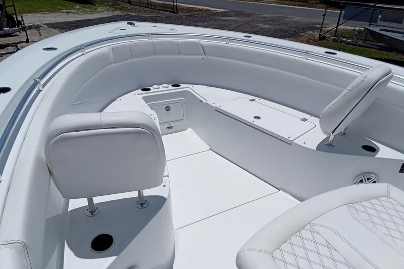 Slide: The Image of 2022 Sportsman Open 302 Center Console boat interior with white seating and storage compartments. - 32