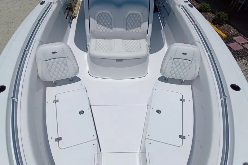 Slide: The Image of 2022 Sportsman Open 302 Center Console boat interior with white seating and storage compartments. - 38