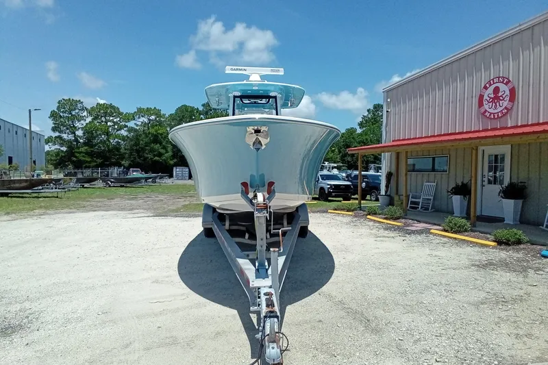 Slide: The Image of 2022 Sportsman Open 302 Center Console boat on trailer, parked outside a building. - 4