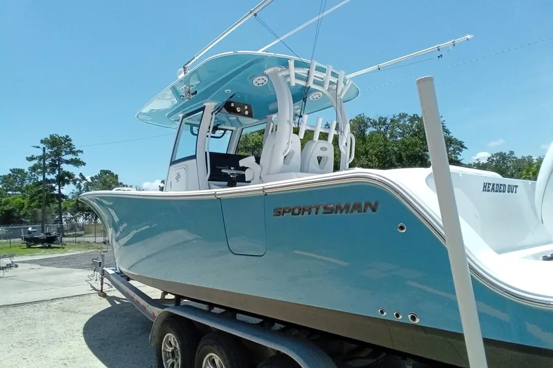 Slide: The Image of 2022 Sportsman Open 302 Center Console boat on trailer, blue hull, sunny day. - 6