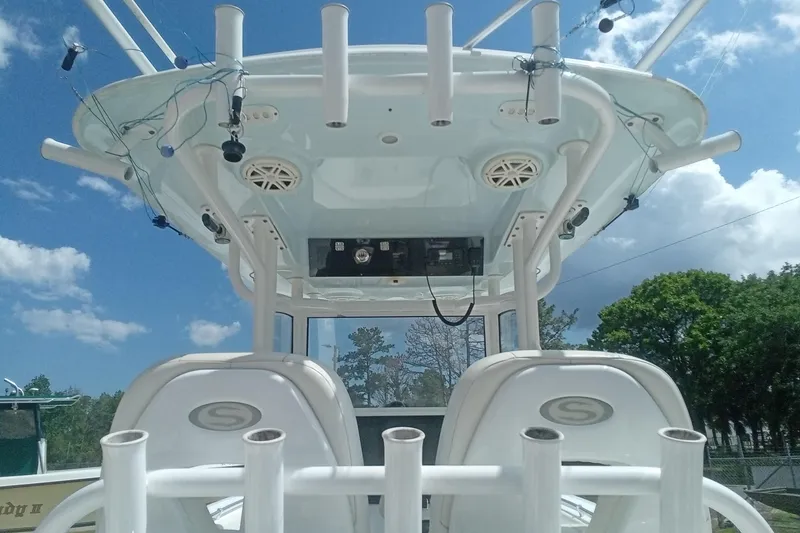 Slide: The Image of 2020 Sportsman Open 282TE Center Console boat with rod holders and speakers under a blue sky. - 11