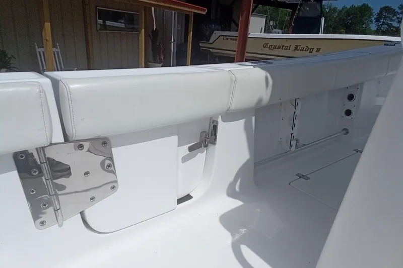 Slide: The Image of 2020 Sportsman Open 282TE Center Console boat interior with white seating and metal fixtures. - 12