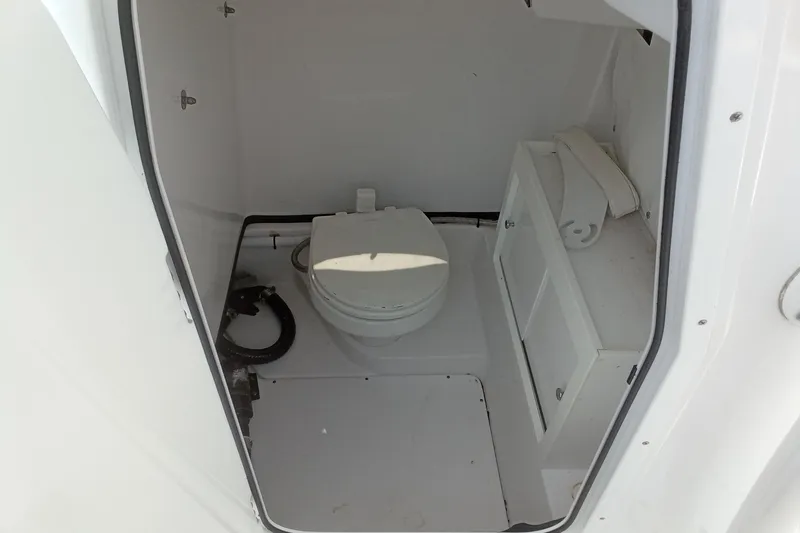 Slide: The Image of 2020 Sportsman Open 282TE Center Console boat interior with toilet and storage. - 21