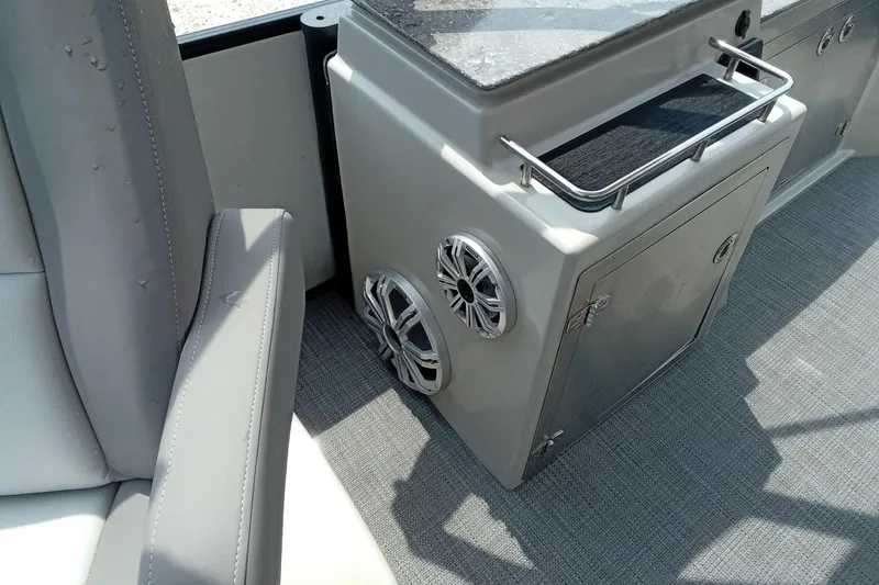 Slide: The Image of 2019 Starcraft MX 23 C boat interior with speakers and storage compartment. - 16
