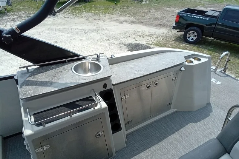 Slide: The Image of 2019 Starcraft MX 23 C boat interior with sink, storage cabinets, and cup holders. - 19
