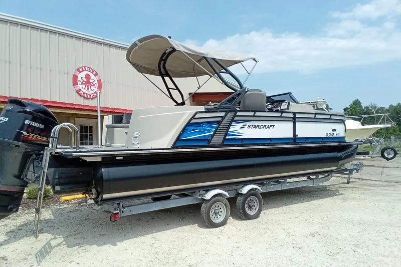 Slide: The Image of 2019 Starcraft MX 23 C pontoon boat on trailer, parked outside a building. - 30