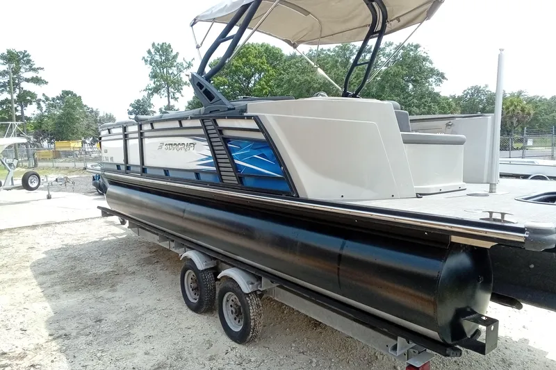 Slide: The Image of 2019 Starcraft MX 23 C pontoon boat on trailer, featuring sleek design and canopy. - 33