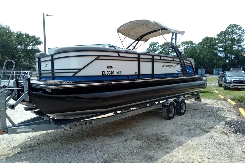 Slide: The Image of 2019 Starcraft MX 23 C pontoon boat on trailer, parked outdoors. - 34