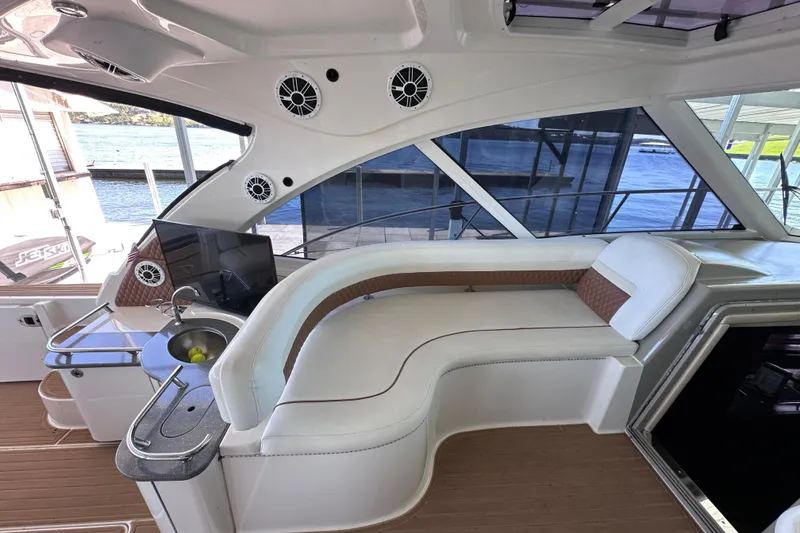 Slide: The Image of 2005 Sea Ray 48 Sundancer yacht docked under a covered marina with scenic lake view. - 13