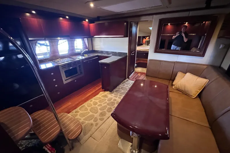 Slide: The Image of 2005 Sea Ray 48 Sundancer interior with elegant seating and wooden table. - 17