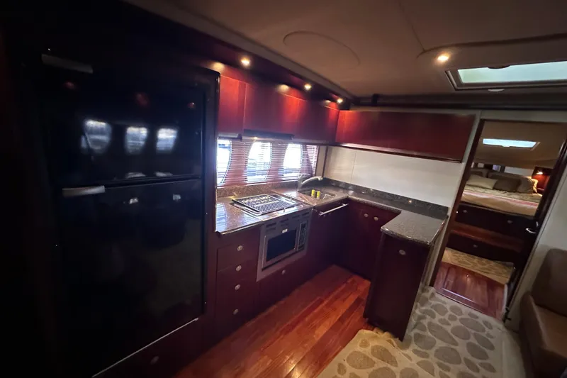 Slide: The Image of 2005 Sea Ray 48 Sundancer helm with dual white leather seats and advanced navigation controls. - 27