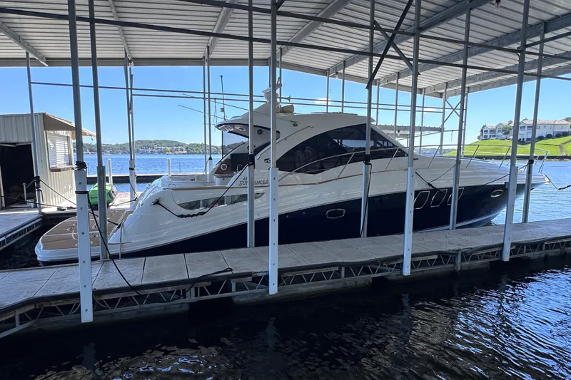 Slide: The Image of 2005 Sea Ray 48 Sundancer yacht cruising on a serene lake under a clear blue sky. - 3