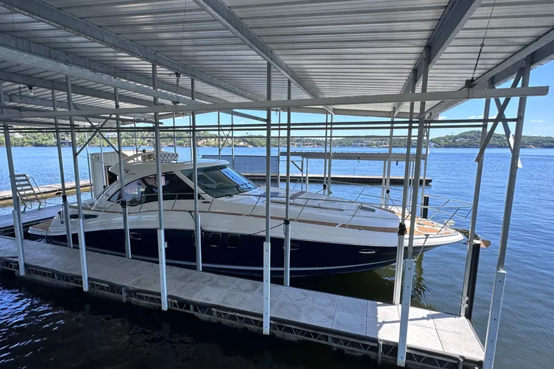 Slide: The Image of 2005 Sea Ray 48 Sundancer yacht cruising on a scenic lake under clear blue skies. - 5