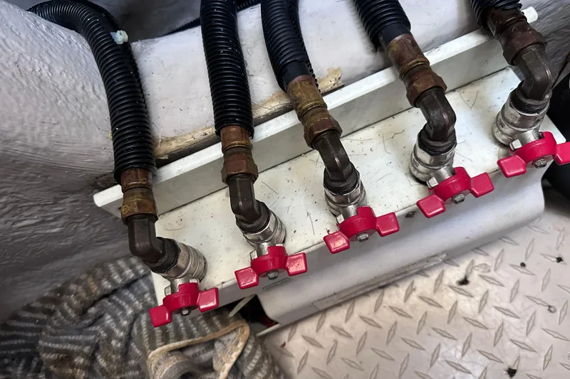 Slide: The Image of Close-up of 2005 Sea Ray 48 Sundancer engine valves with red handles and black hoses. - 55