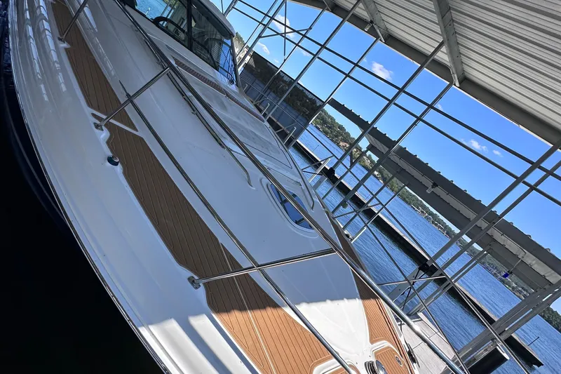 Slide: The Image of 2005 Sea Ray 48 Sundancer yacht cruising on a serene lake under clear blue skies. - 7