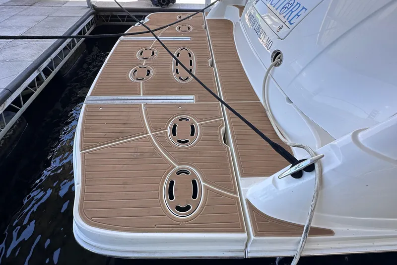 Slide: The Image of 2005 Sea Ray 48 Sundancer yacht cruising on a serene lake with lush green shoreline. - 9