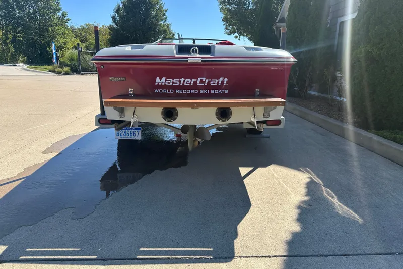Slide: The Image of 1987 MasterCraft ProStar 190 boat on driveway, rear view, sunny day. - 2