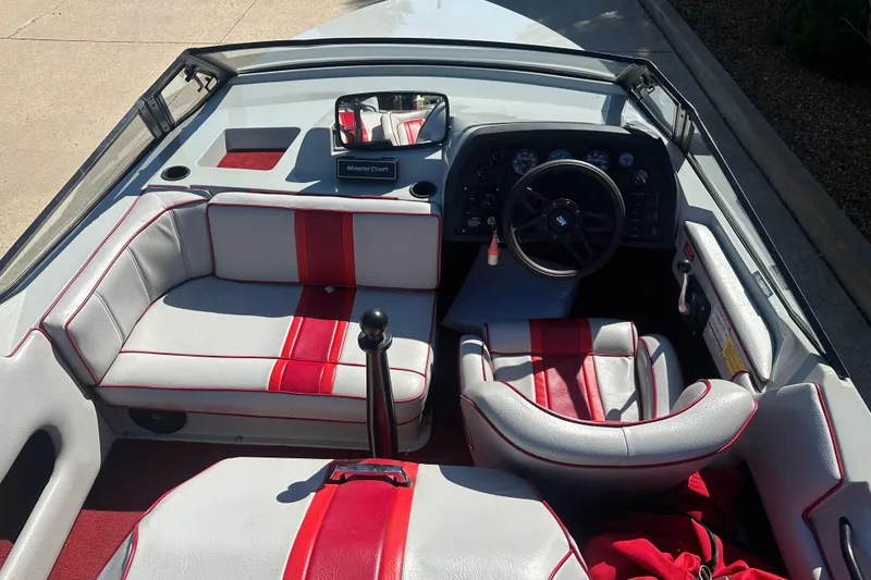 Slide: The Image of 1987 MasterCraft ProStar 190 boat interior with red and gray seating, steering wheel, and dashboard. - 3