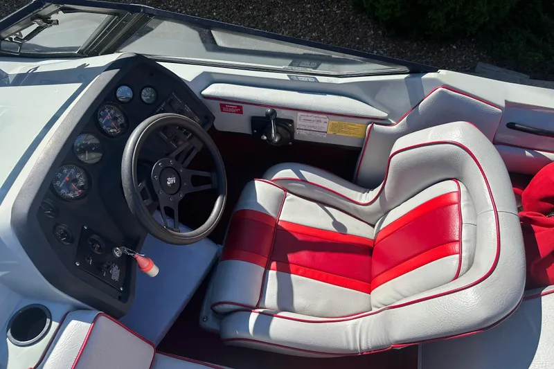 Slide: The Image of 1987 MasterCraft ProStar 190 boat interior with red and white seating and dashboard controls. - 4