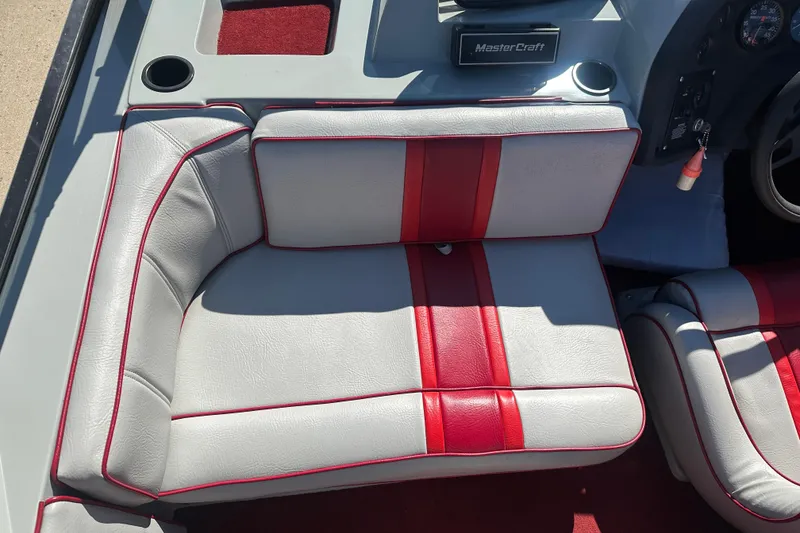 Slide: The Image of 1987 MasterCraft ProStar 190 interior with red and gray seating, cup holders, and dashboard details. - 8