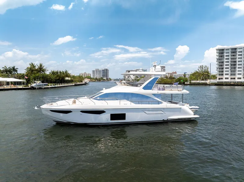 Slide: The Image of 2022 Azimut Fly 60 yacht cruising on a sunny day in a coastal waterway. - 17