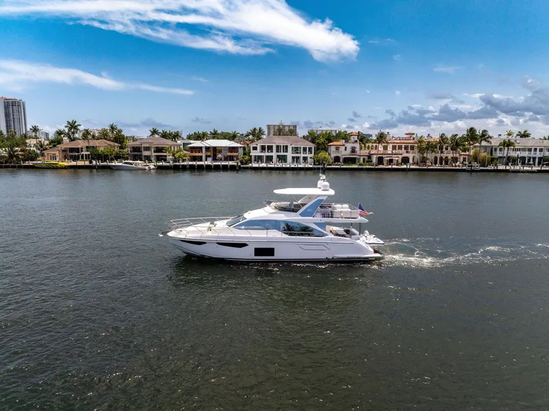 Slide: The Image of Azimut Fly 60 yacht cruising on a sunny day, 2022 model, near waterfront homes. - 21
