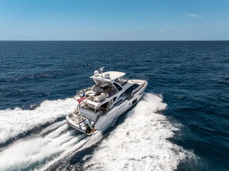 Slide: The Image of Azimut Fly 60 yacht cruising on open sea, 2022 model, creating waves under clear blue sky. - 9