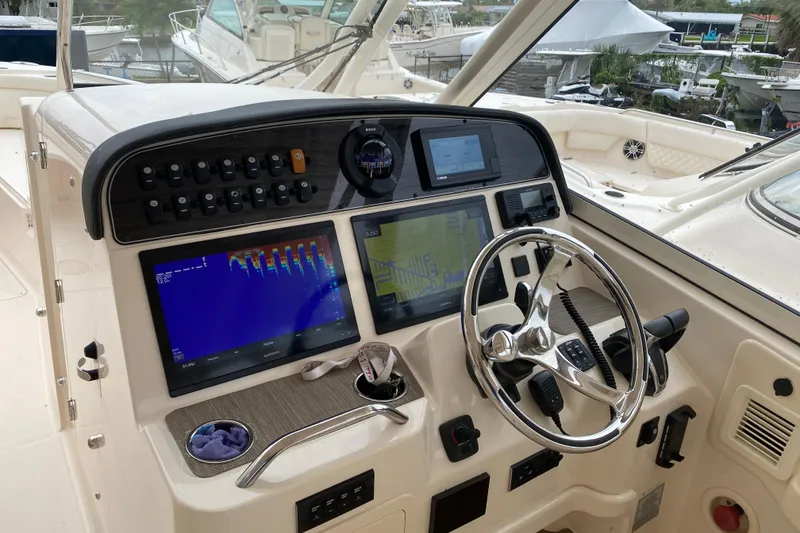 Slide: The Image of 2021 Grady-White Freedom 335 boat dashboard with navigation screens and steering wheel. - 5