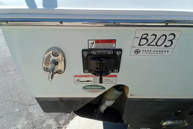 Slide: The Image of 2019 Sea Hunt Ultra 255 SE boat stern with safety labels and Safe Harbor sticker. - 11