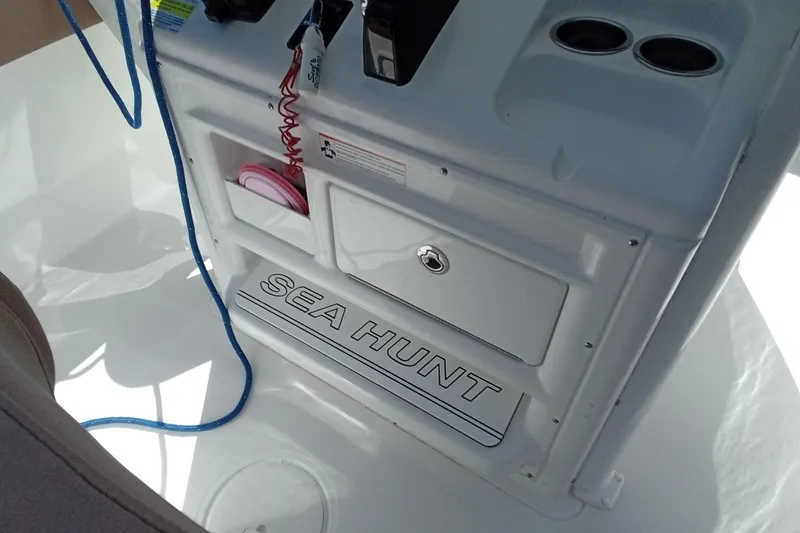 Slide: The Image of 2019 Sea Hunt Ultra 255 SE boat interior with storage compartments and cup holders. - 18