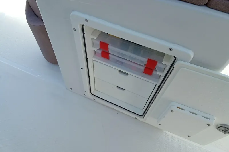 Slide: The Image of Storage compartment on a 2019 Sea Hunt Ultra 255 SE boat with tackle boxes. - 23