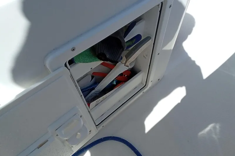 Slide: The Image of Storage compartment on 2019 Sea Hunt Ultra 255 SE boat with tools and accessories. - 24