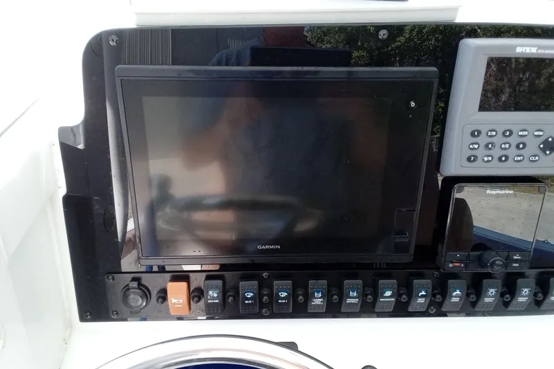Slide: The Image of Control panel of a 2019 Sea Hunt Ultra 255 SE boat with Garmin and Raymarine displays. - 28