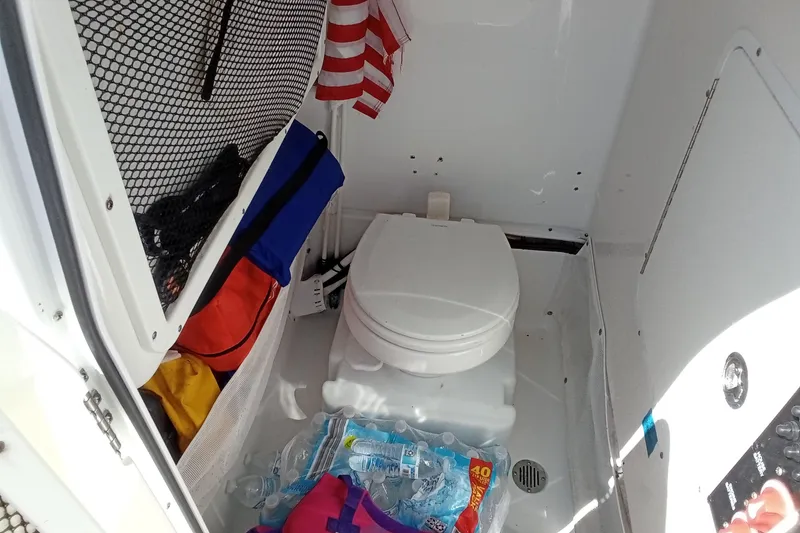 Slide: The Image of Interior of 2019 Sea Hunt Ultra 255 SE boat with toilet and storage items. - 31