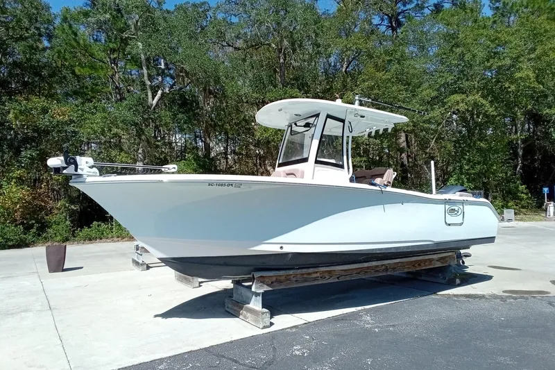 Slide: The Image of 2019 Sea Hunt Ultra 255 SE boat on a trailer, surrounded by trees. - 4