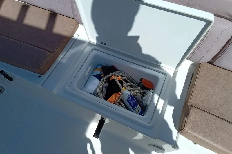 Slide: The Image of Storage compartment on a 2019 Sea Hunt Ultra 255 SE boat with various items inside. - 41