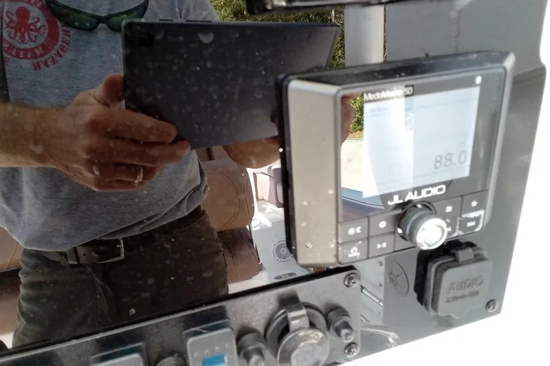 Slide: The Image of 2019 Sea Hunt Ultra 255 SE dashboard with JL Audio system and reflection. - 48