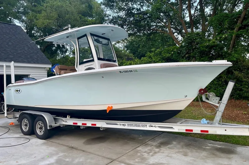 Slide: The Image of 2019 Sea Hunt Ultra 255 SE boat on trailer, parked near a garage. - 50