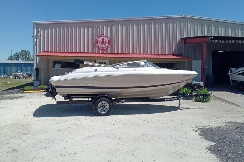 Slide: The Image of 2014 Regal 2000 Bowrider boat on trailer outside a metal building. - 2