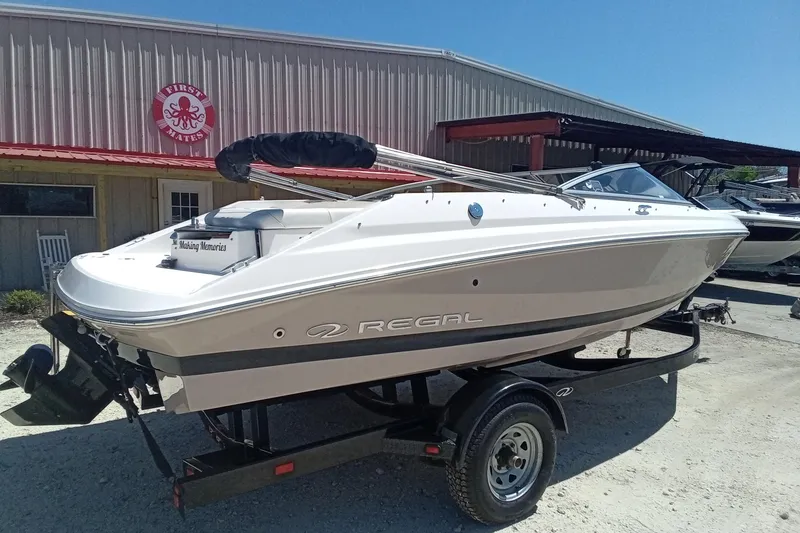 Slide: The Image of 2014 Regal 2000 Bowrider boat on trailer outside a marine shop. - 7