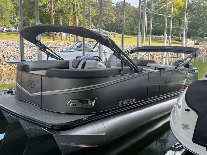 Slide: The Image of 2021 Avalon LSZ 2485 Ent pontoon boat docked, featuring sleek design and spacious seating. - 1