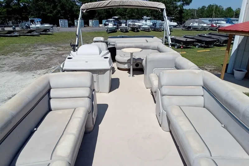 Slide: The Image of 2003 Godfrey SANPAN 2500 pontoon boat with spacious seating and canopy, docked outdoors. - 12